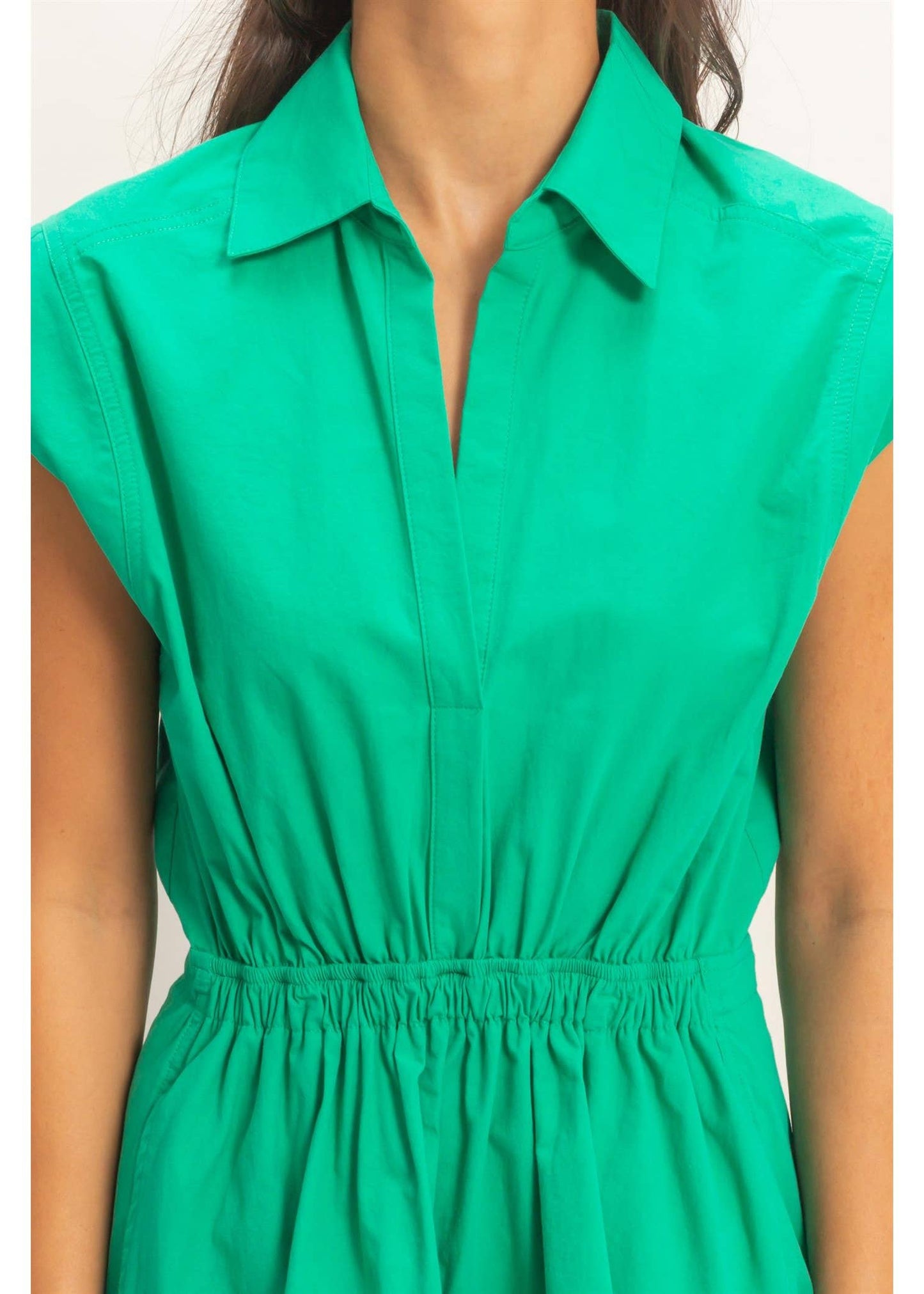 Green dress worn by a person on a white background