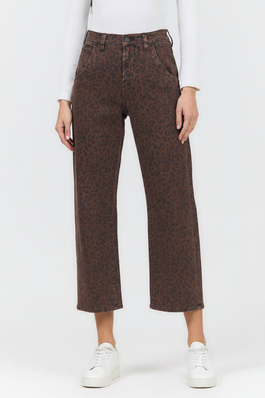 A model wearing brown leopard-print cropped jeans with a white long-sleeve top and black pointed-toe mule heels, shown from the waist down on a white studio background.