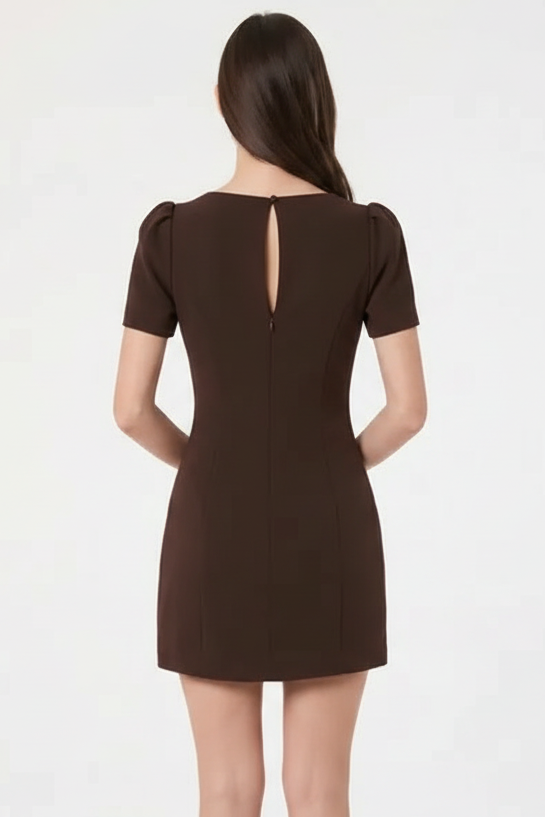 A woman viewed from the back wearing a short-sleeve burgundy dress with a small keyhole cutout at the back, set against a plain white studio background.