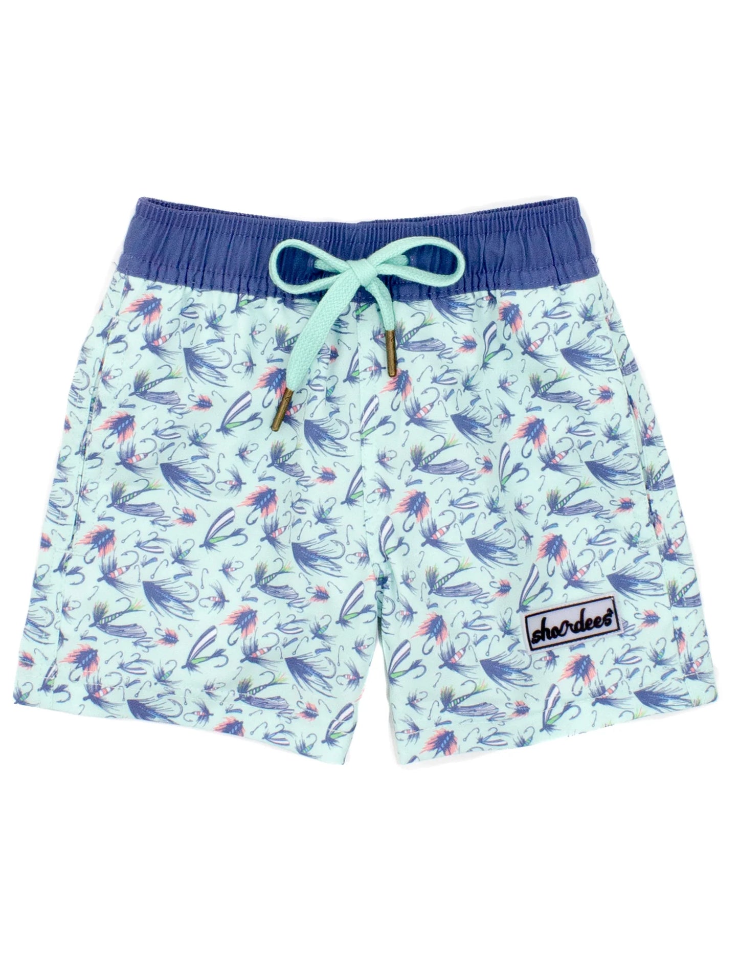 A pair of boys' swim trunks with a geometric pattern featuring airplanes and the text 'properly tied' on the waistband.