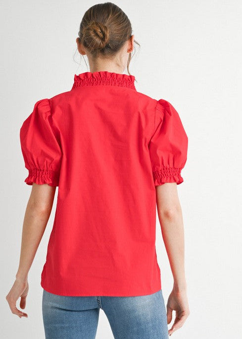 Person wearing a red blouse with puff sleeves on a white background