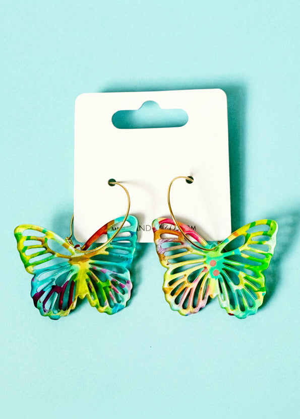 Colorful butterfly-shaped earrings on a branded card against a light blue background