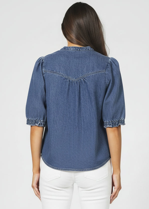 Person wearing a blue denim shirt and jeans on a white background