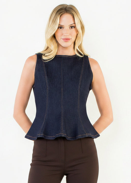 A blonde woman modeling a sleeveless dark indigo denim peplum top with white pants, standing against a plain white studio background.