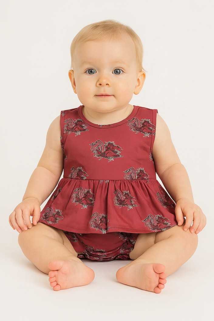 Baby wearing a red floral dress and bloomers on a white background
