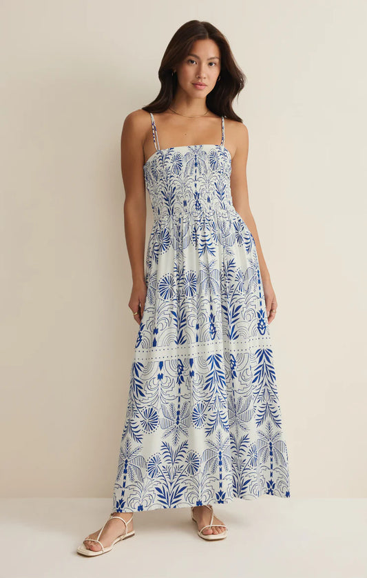 Woman wearing a blue and white floral dress against a beige background