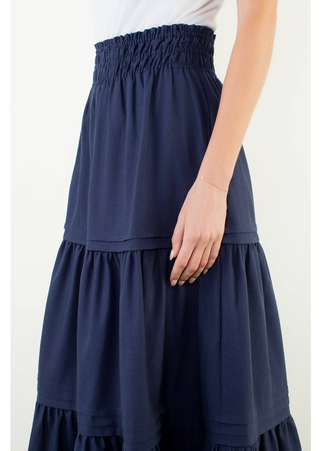 Navy blue tiered skirt worn by a person on a white background