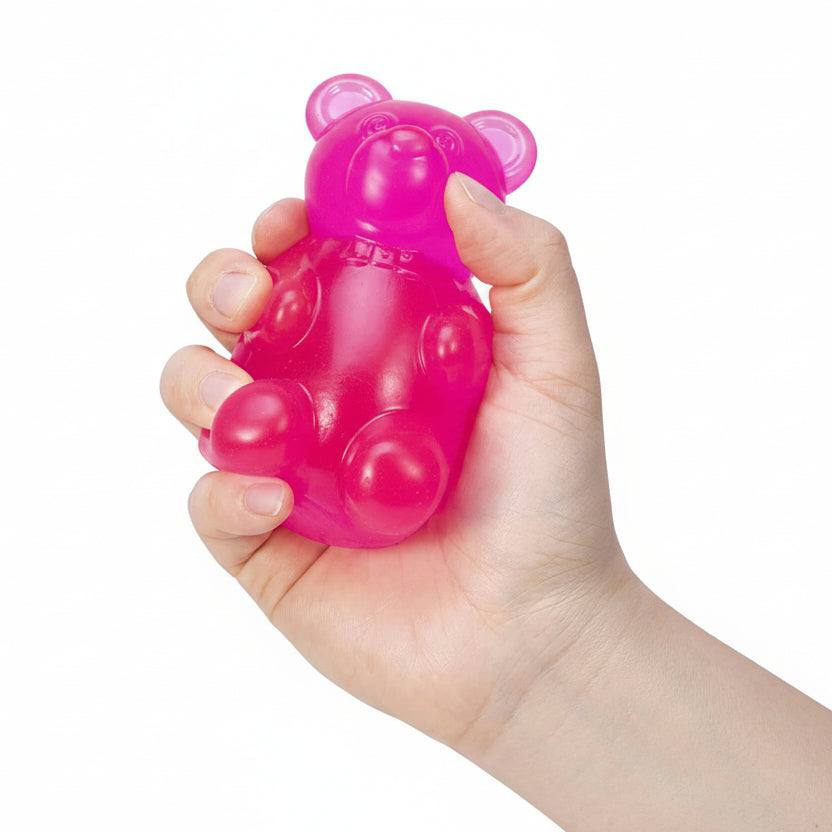 Hand holding a pink bear-shaped toy with a white background