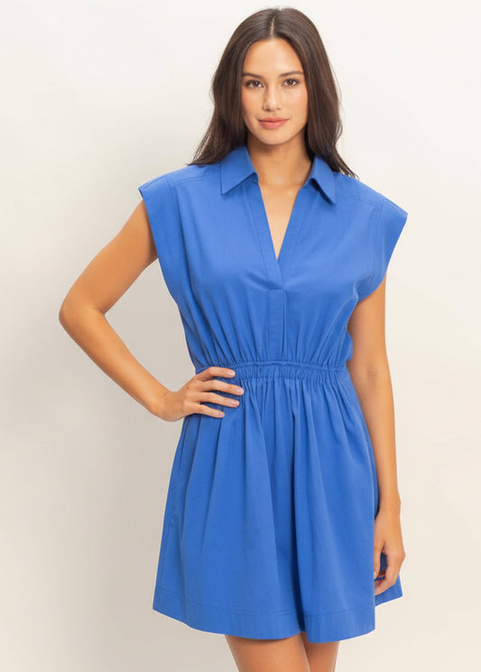 Woman wearing a blue dress against a plain background