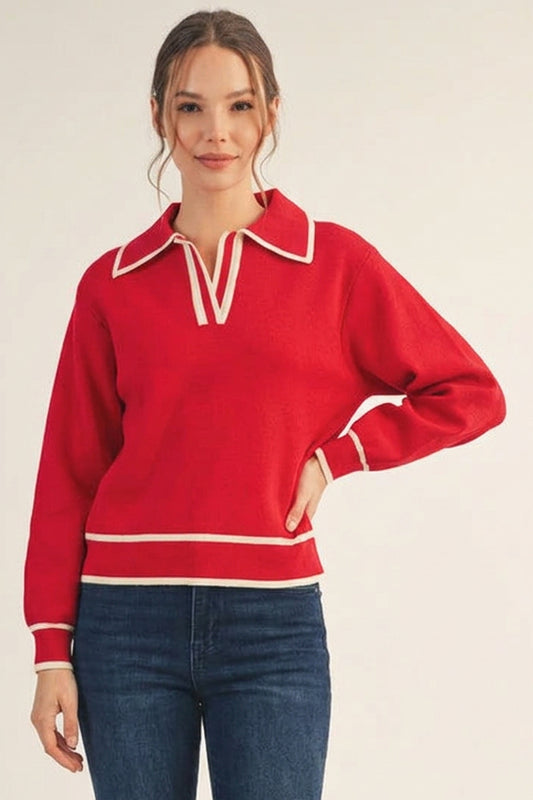 Woman wearing a red sweater with white trim on a beige background
