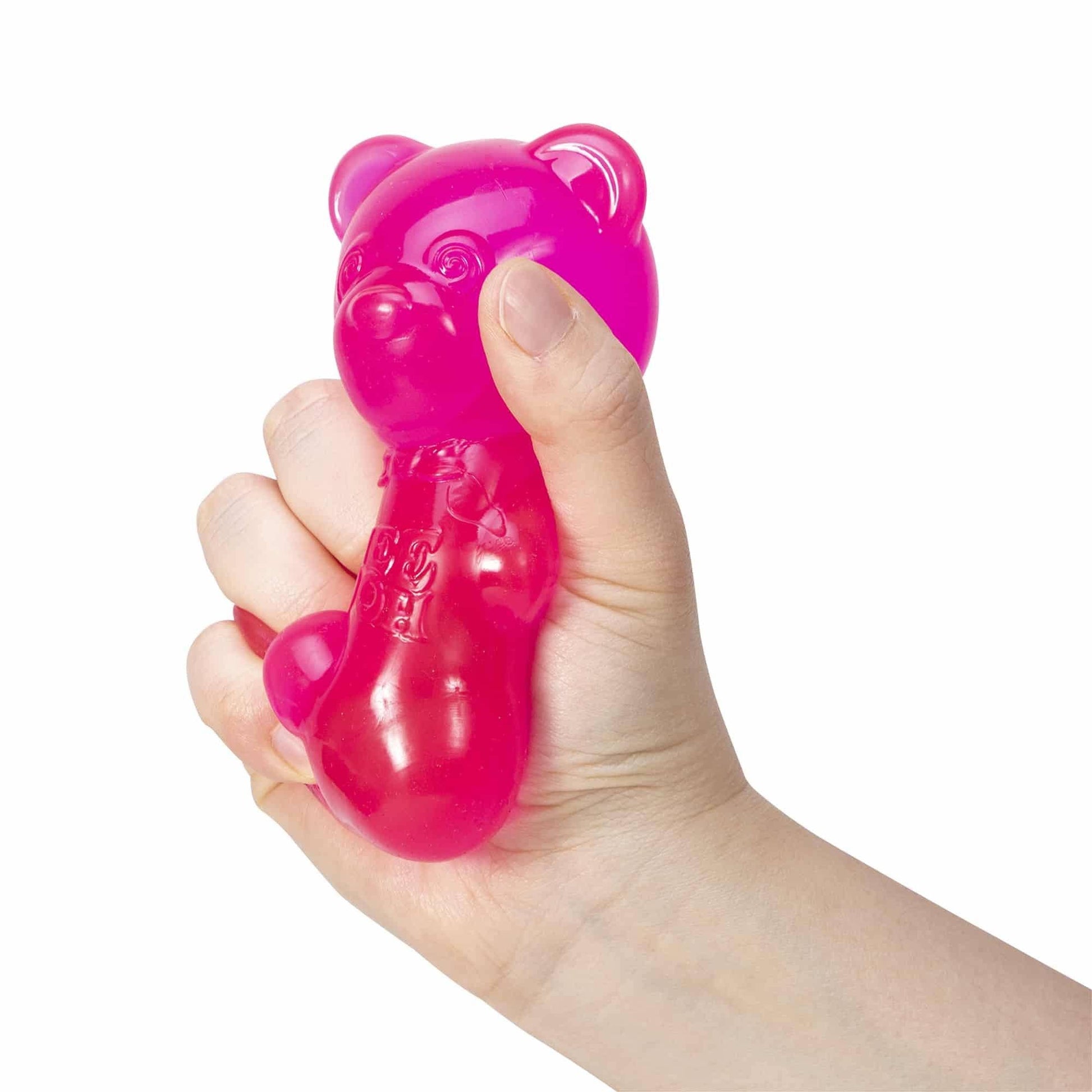 Pink dog toy shaped like a bear held in a hand against a white background