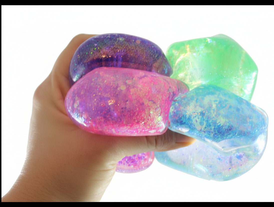Colorful glittery stones held in a hand with 'Curious Minds' branding.