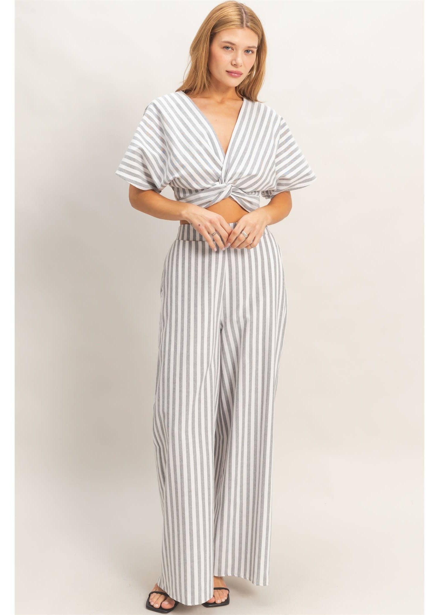 Woman wearing a striped jumpsuit on a plain background