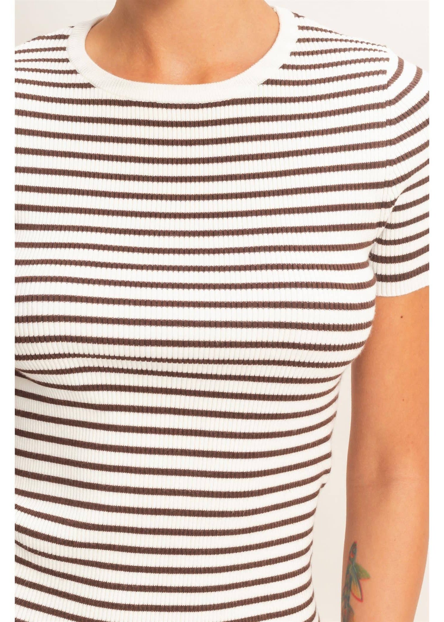 Close-up of a person wearing a white t-shirt with brown horizontal stripes on a white background.