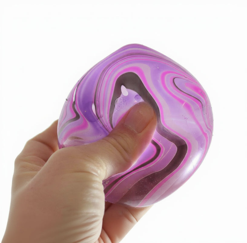 Hand holding a marbled purple and pink object with 'Curious Minds' branding.