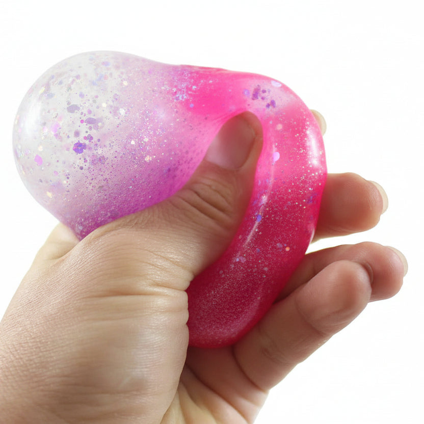 Hand holding a glittery purple heart-shaped object with 'Curious Minds Busy Bags' logo.