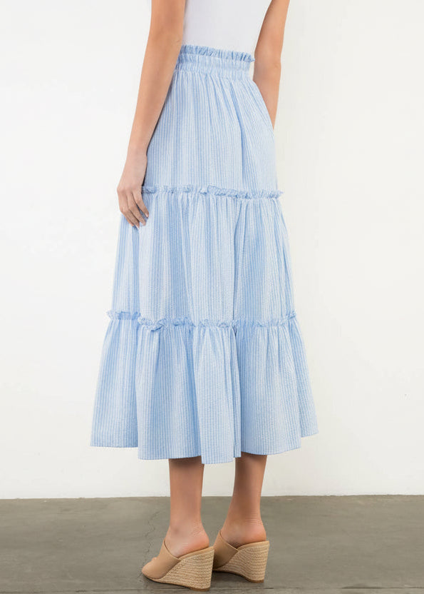 Light blue tiered skirt worn by a person on a white background