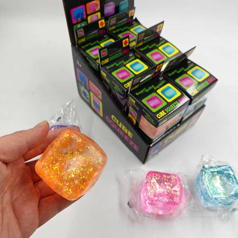 Colorful cube-shaped squishies with packaging on a white background