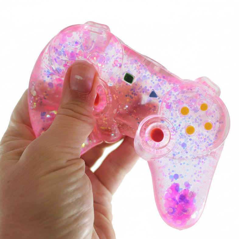 Pink and clear glittery toy held by a hand with 'Curious Minds' branding.