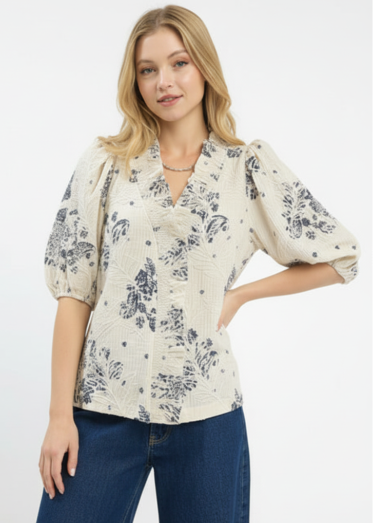 Woman wearing a floral blouse with puff sleeves on a white background