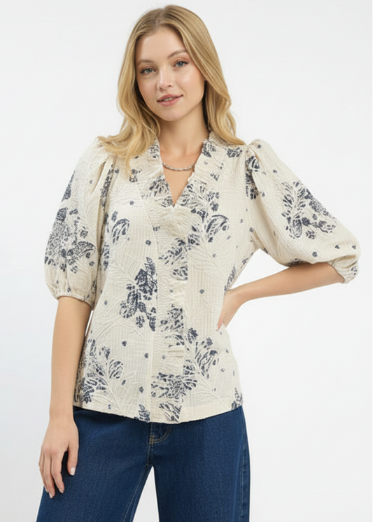 Woman wearing a floral blouse with puff sleeves on a white background