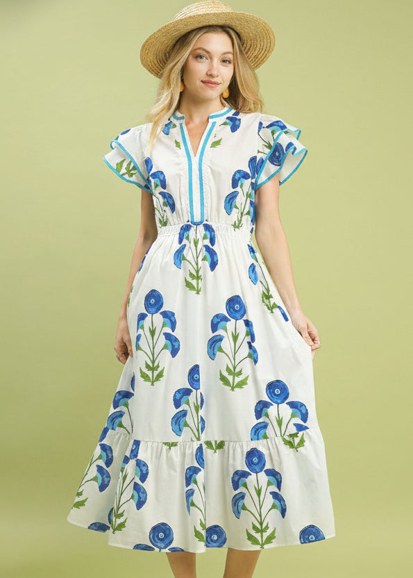 Woman wearing a floral dress with a straw hat on a green background