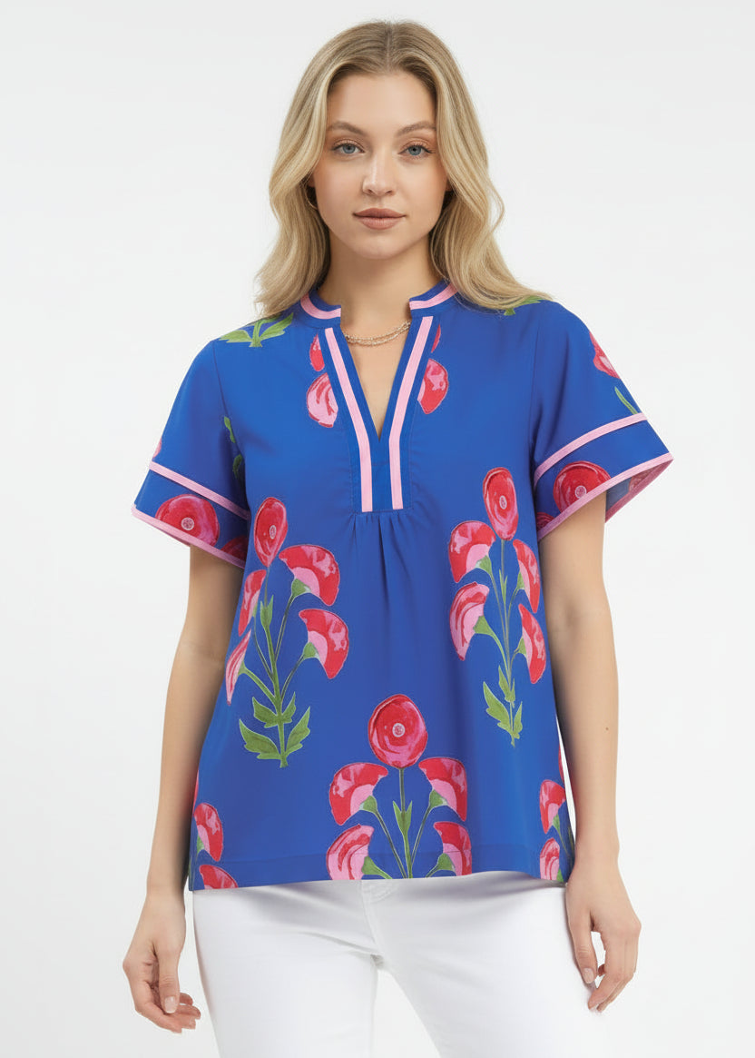 Woman wearing a blue floral blouse with pink flowers on a white background