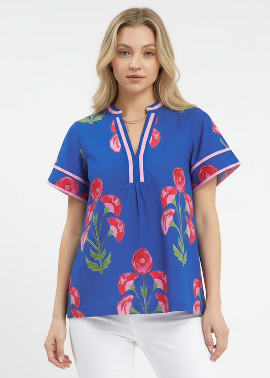 Woman wearing a blue floral blouse with pink flowers on a white background