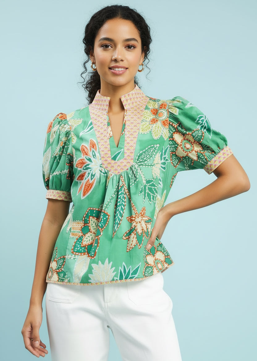 Woman wearing a floral blouse with a green background