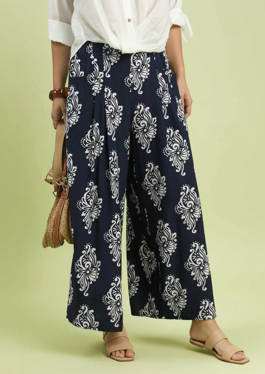 Navy blue pants with white floral patterns worn by a person on a light green background