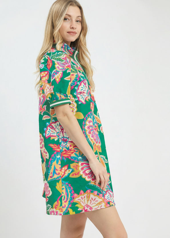 Woman wearing a colorful floral dress on a white background with 'UMgee Exclusive' branding.