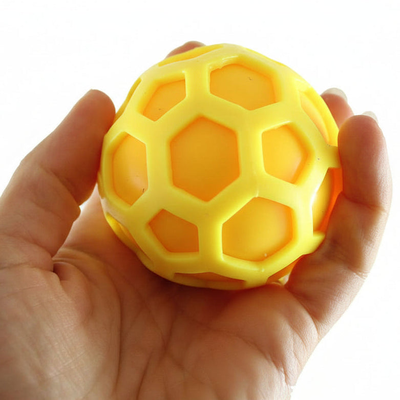 Yellow textured ball held in a hand with 'Curious Minds' branding.
