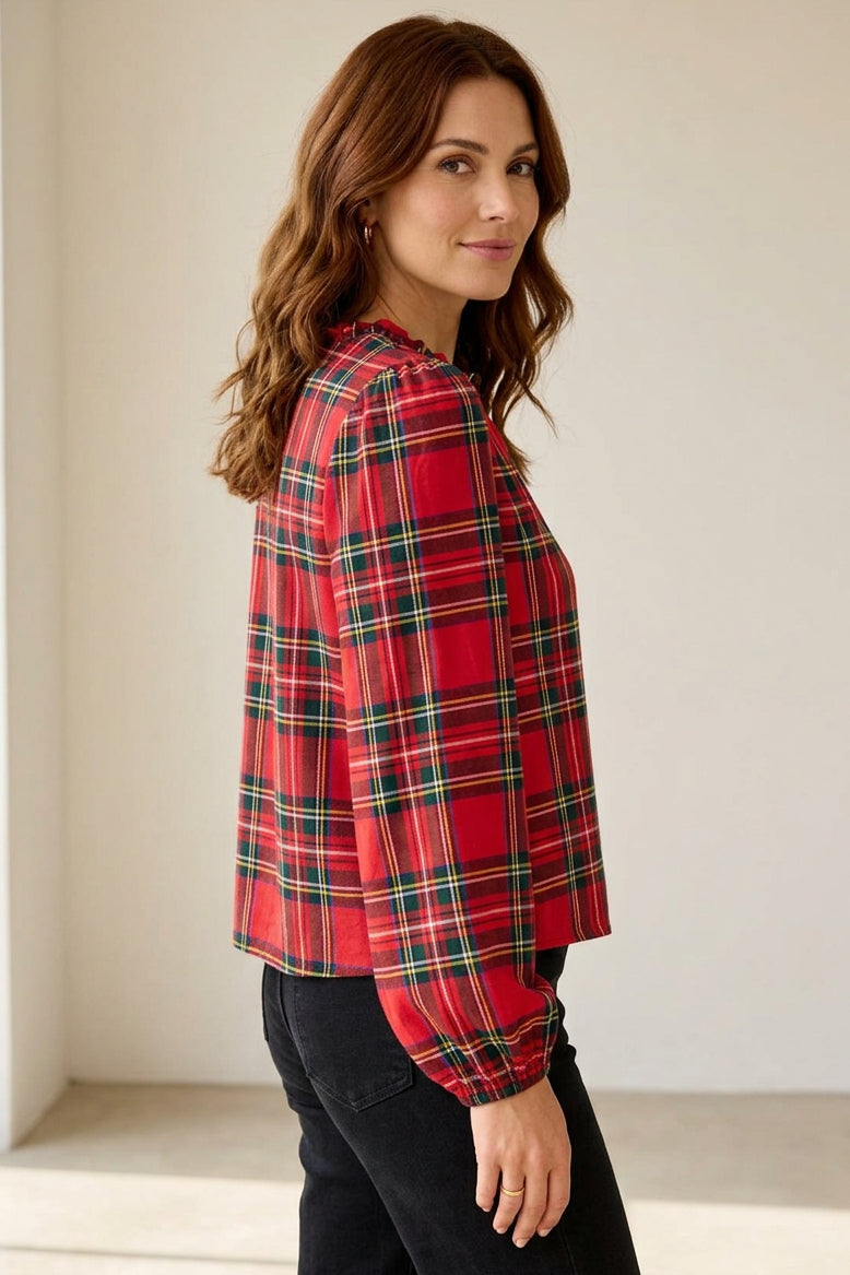 Woman wearing a red plaid shirt against a beige background