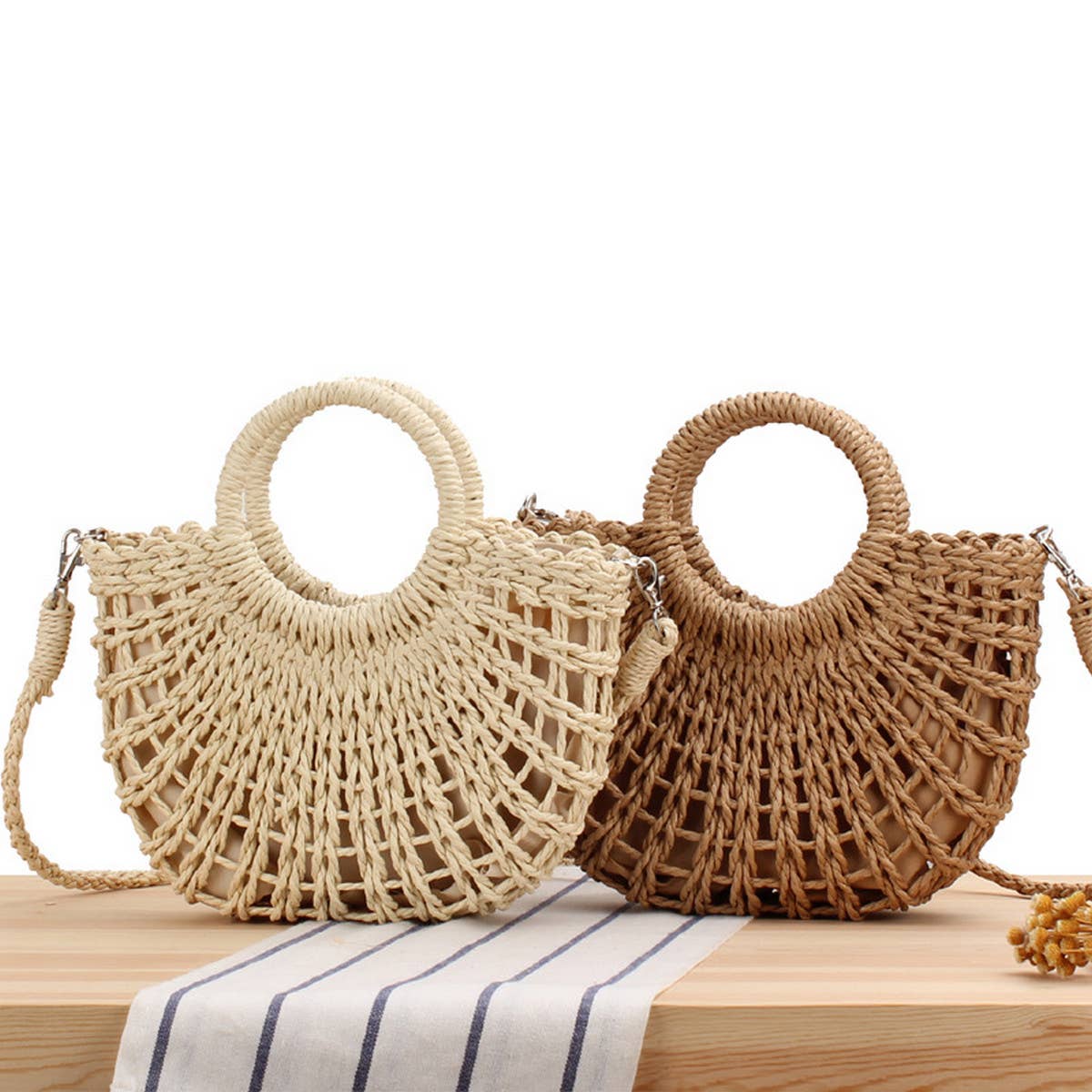 Two woven handbags, one beige and one brown, on a wooden surface with a white background.