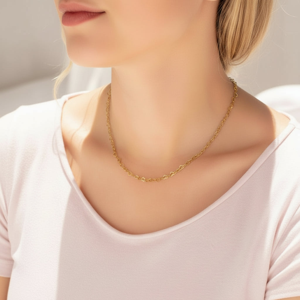 Gold necklace on a person wearing a white top