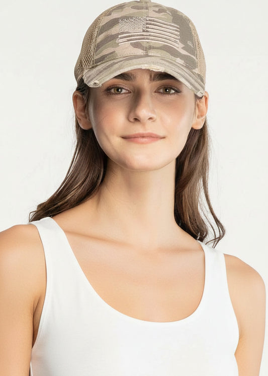 Person wearing a camouflage cap with an American flag design on a white background