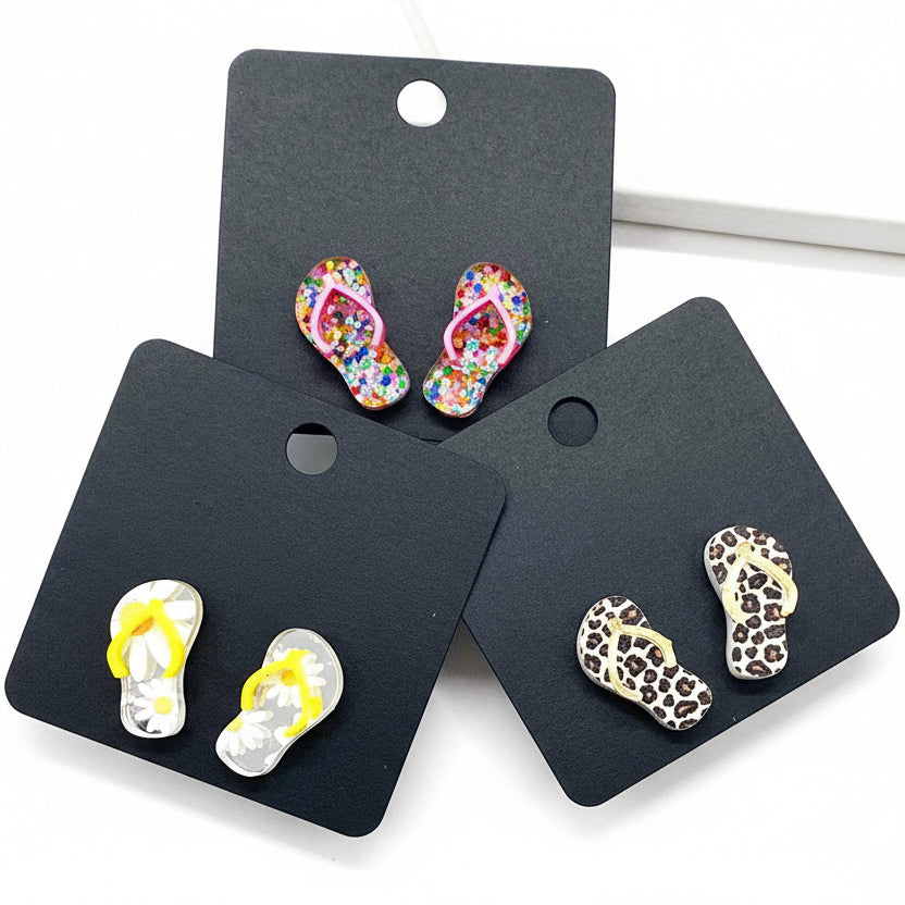 Flip-flop-shaped earrings on 'Doohickies' branded cards against a white background