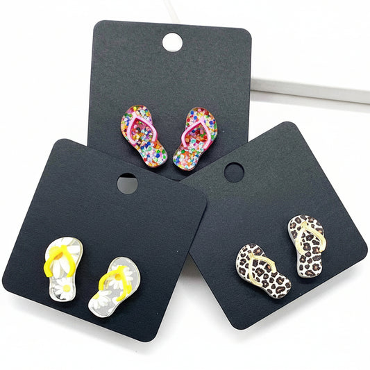 Flip-flop-shaped earrings on 'Doohickies' branded cards against a white background