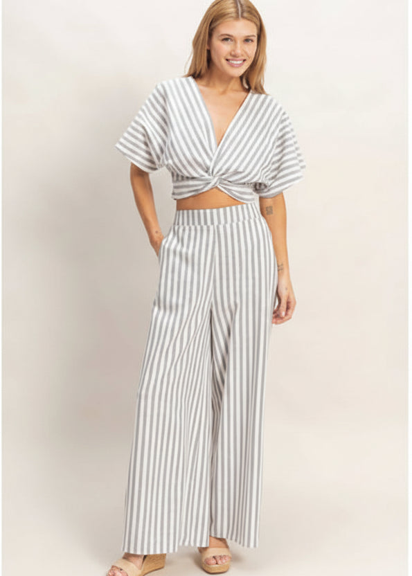 Woman wearing a striped two-piece outfit on a plain background