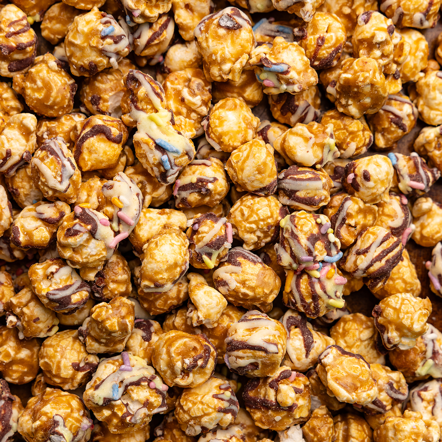 Close-up of chocolate-dipped popcorn with colorful sprinkles.