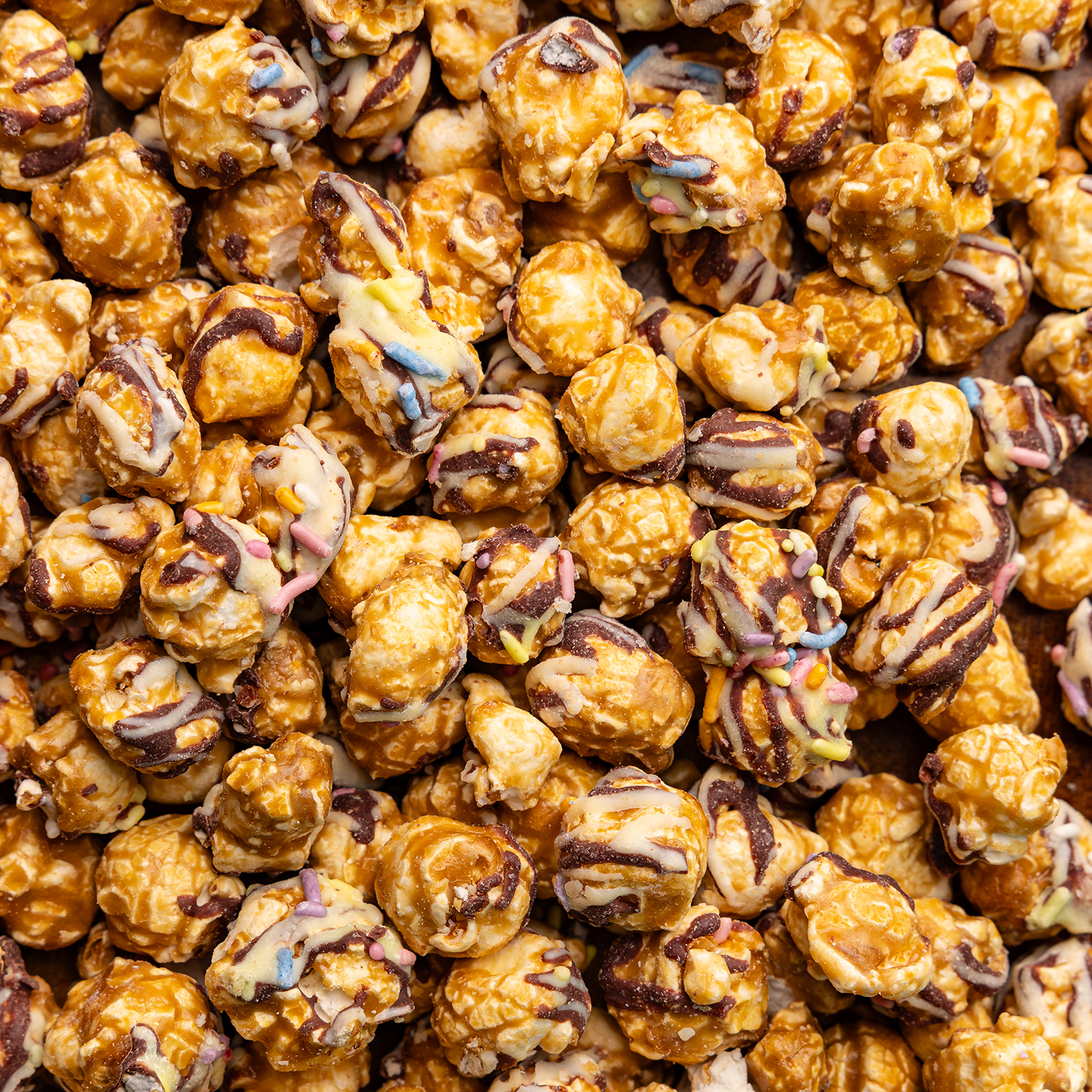 Close-up of chocolate-dipped popcorn with colorful sprinkles.