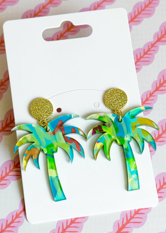 Palm tree earrings on a Sandy Rizzo branded card with a pink and white striped background