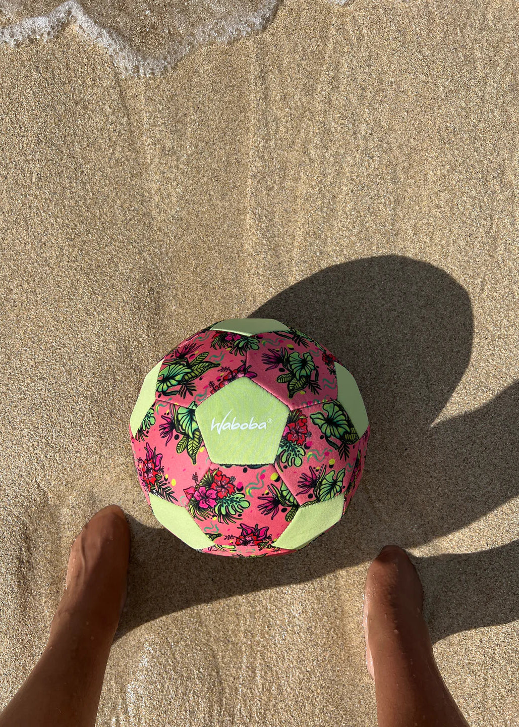 Floral-patterned ball on a sandy surface