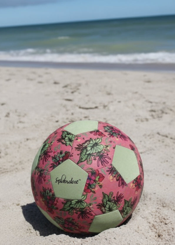 Colorful beach ball on a sandy beach with ocean in the background