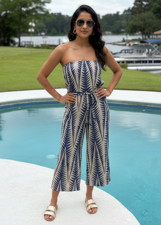 Woman in a strapless dress with a blue and white pattern standing by a pool.