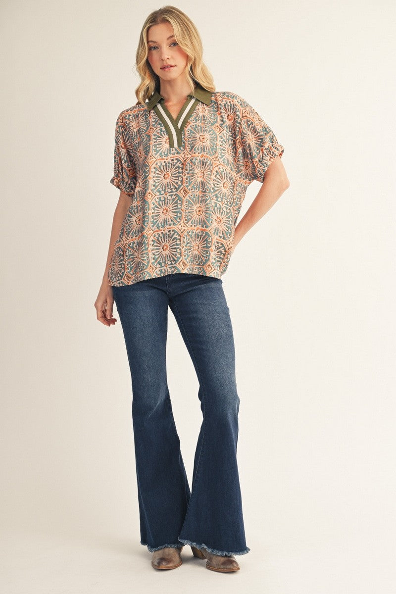 Woman wearing a patterned blouse and blue jeans on a white background
