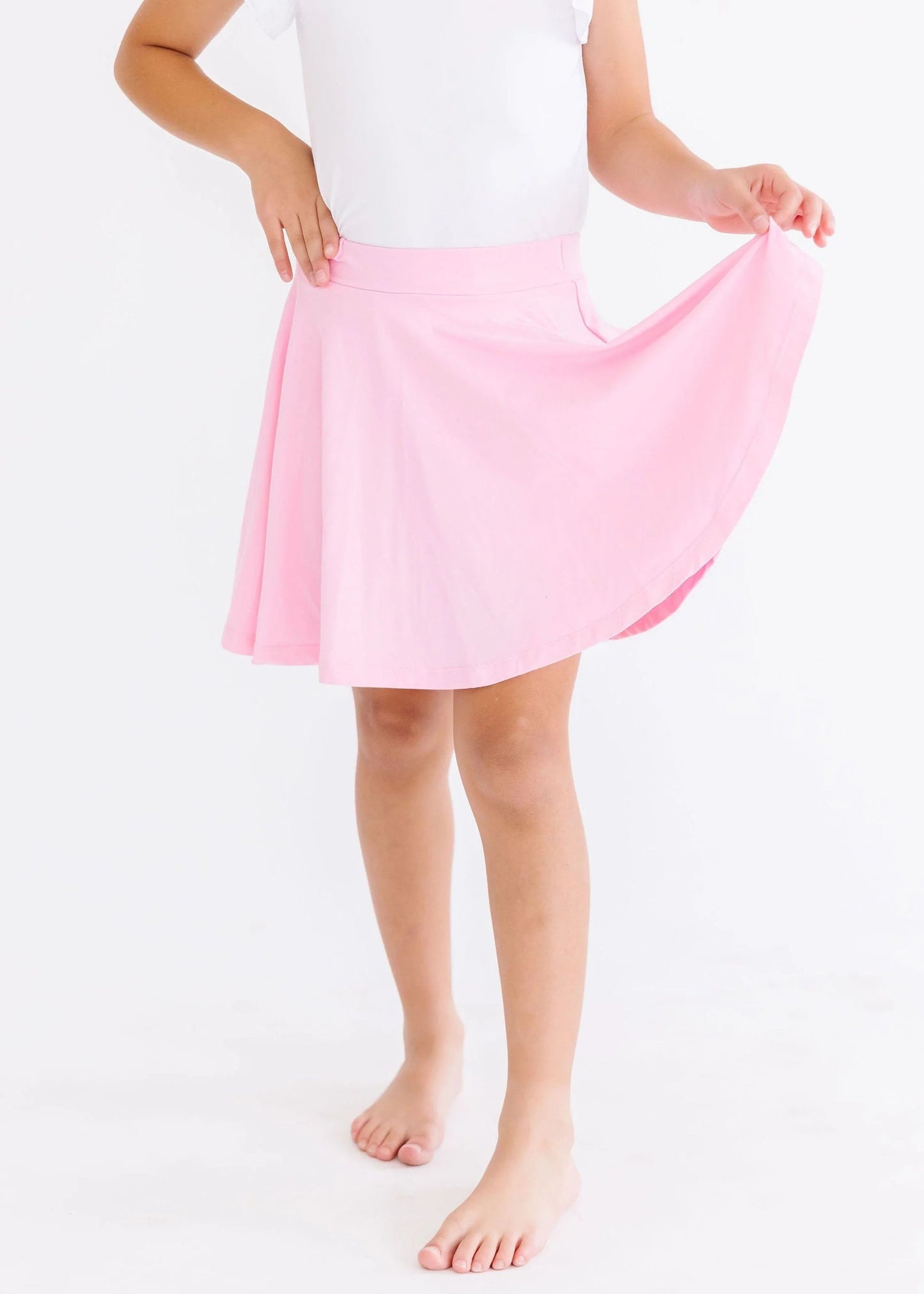 Person holding a pink skirt on a white background