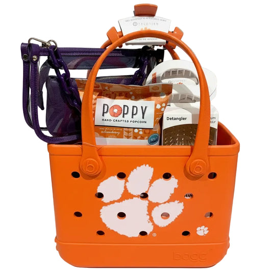 Orange tote bag with paw print and 'Tigers' strap, containing popcorn and detangler products.