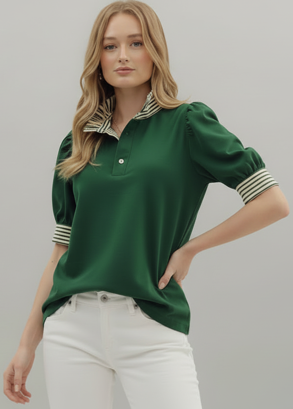 Woman wearing a green polo shirt with white pants on a gray background