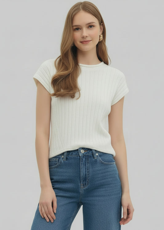 Woman wearing a white sleeveless top and shorts on a plain background